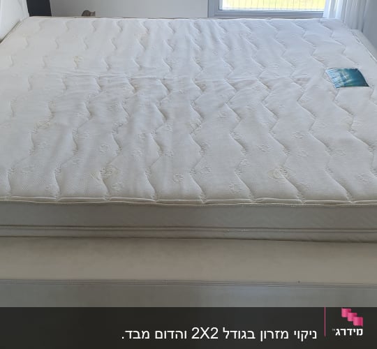 מזרן לבן על מיטה בחדר מואר